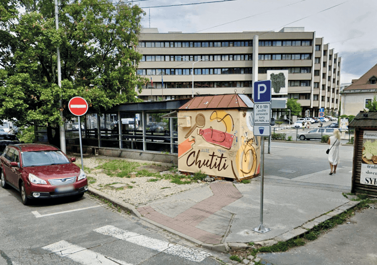 Pohľad na zastávku mestskej hromadnej dopravy Zochova. V centre je vidno starý opustený stánok.